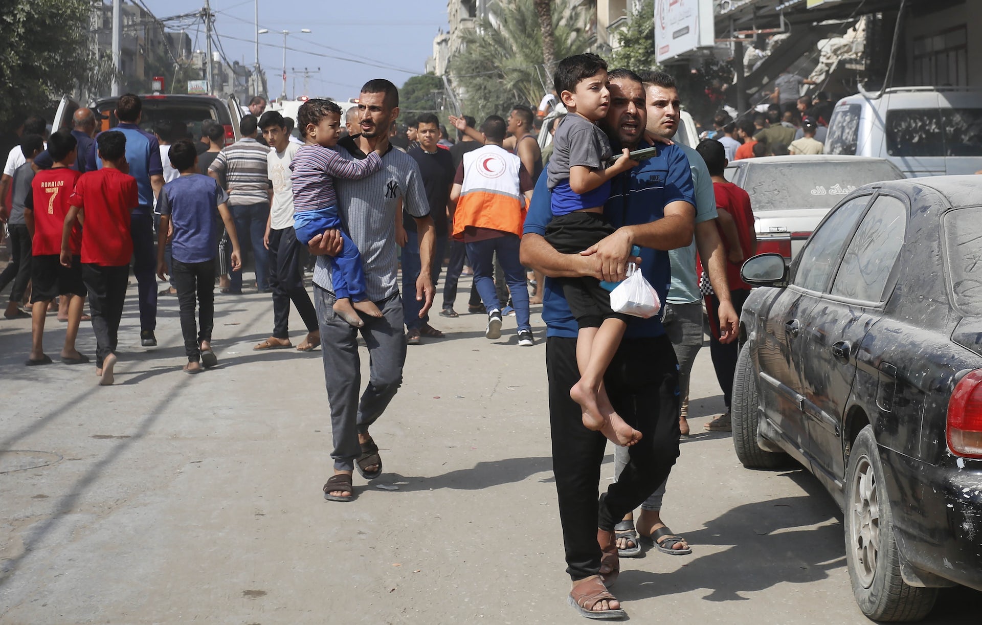 Famílias, segurando crianças em seus braços, deixam áreas próximas aos combates em Gaza.